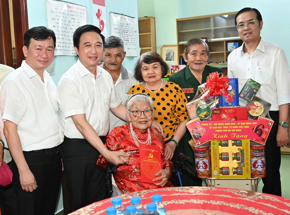 胡志明市市委副书记邓明通和延鸿坊党委书记黎文明向陈氏发大娘赠送礼物。
