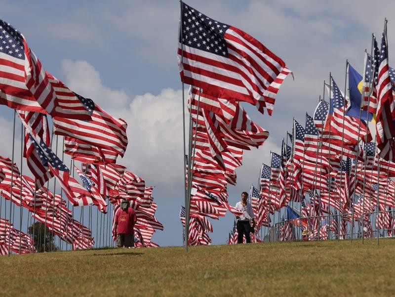 9月10日，在美国加利福尼亚州洛杉矶县马里布，人们从佩珀代因大学草坪上的“旗海”中走过。新华社照片