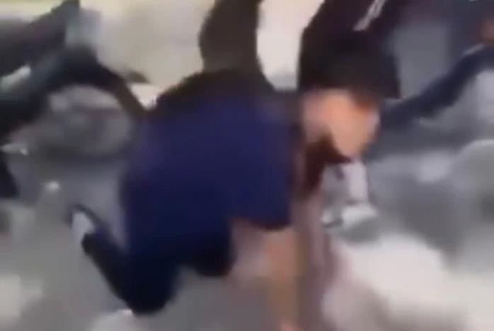 男生被迫在地上爬行。截图自视频。