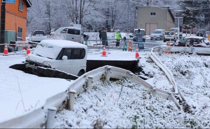 一辆汽车坠入因地震受损的塌陷道路。