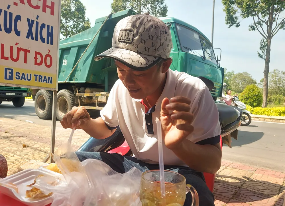 Anh Nguyễn Văn Huy ăn cơm hộp để chờ vào đăng kiểm