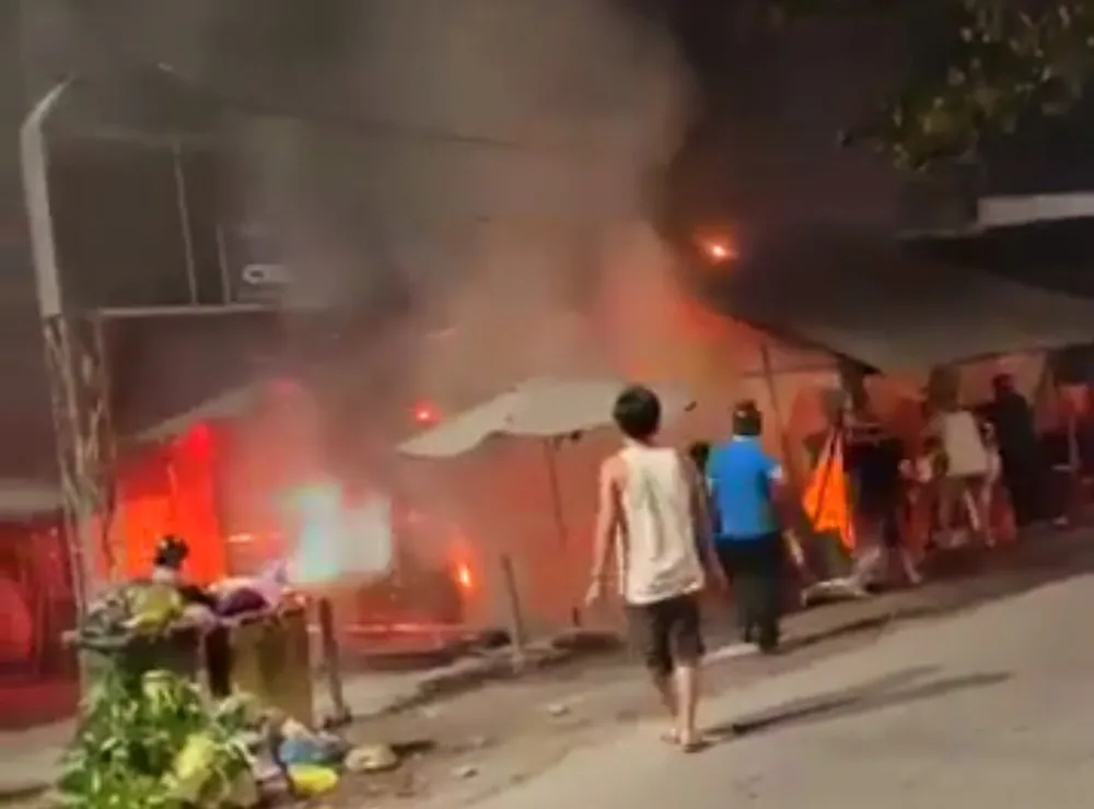 Người dân gần chợ cố gắng dùng bình chữa cháy mini để dập lửa