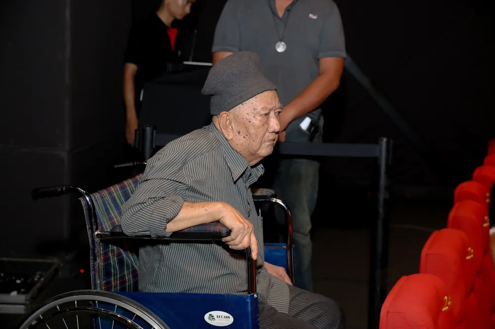 Nghệ sĩ Mạc Can ngồi xe lăn đến theo dõi buổi công chiếu bộ phim