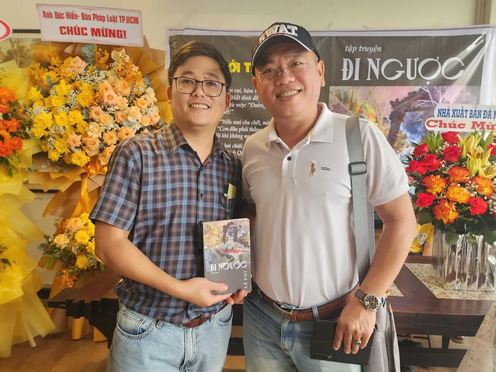 Nhà báo Lê Phi (bìa trái) cùng tác giả bài viết trong buổi ra mắt tập truyện "Đi ngược" 1000024562.jpg