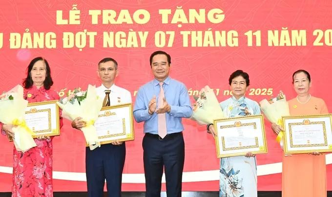 阮文得同志向党员颁发党龄纪念章。图：越勇