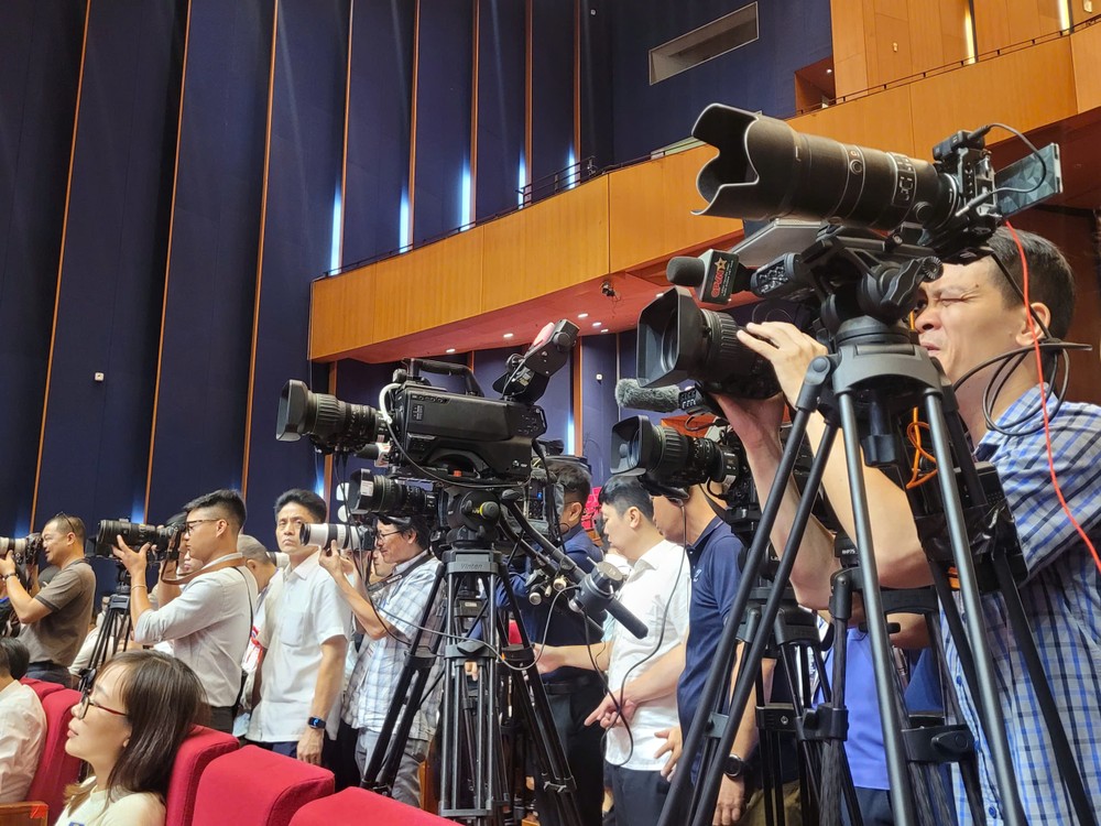 新闻媒体机关记者在会议现场进行报道。