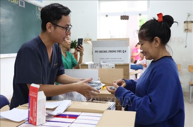 向洪涝灾区民众发放药品。