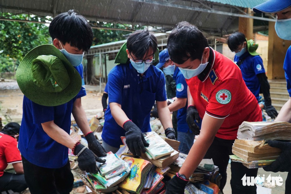 共青团胡志明市市委团员、青年处理被水浸坏的书籍。图：陈怀