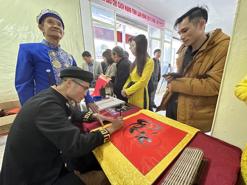 Ban tổ chức viết chữ thư pháp tặng bạn đọc tại Hội Báo Xuân Lâm Đồng