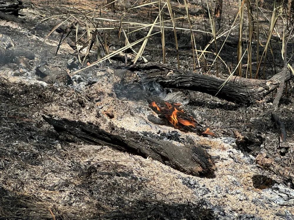 Một số ngọn lửa nhỏ vẫn đang cháy vào sáng 8-4. Ảnh: ĐOÀN KIÊN