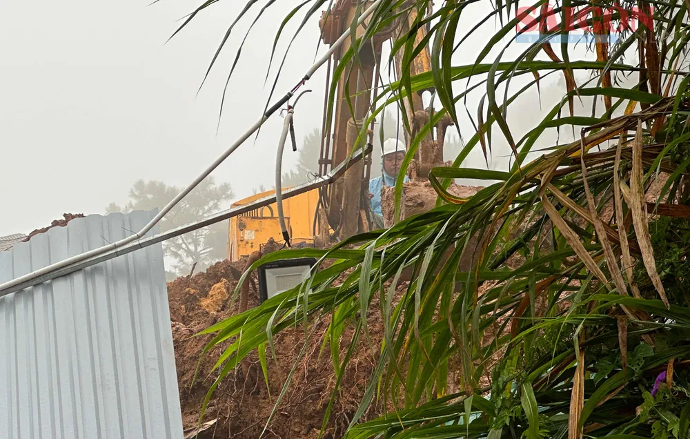 Máy móc được huy động giảm tải bờ trên taluy. Ảnh: ĐOÀN KIÊN