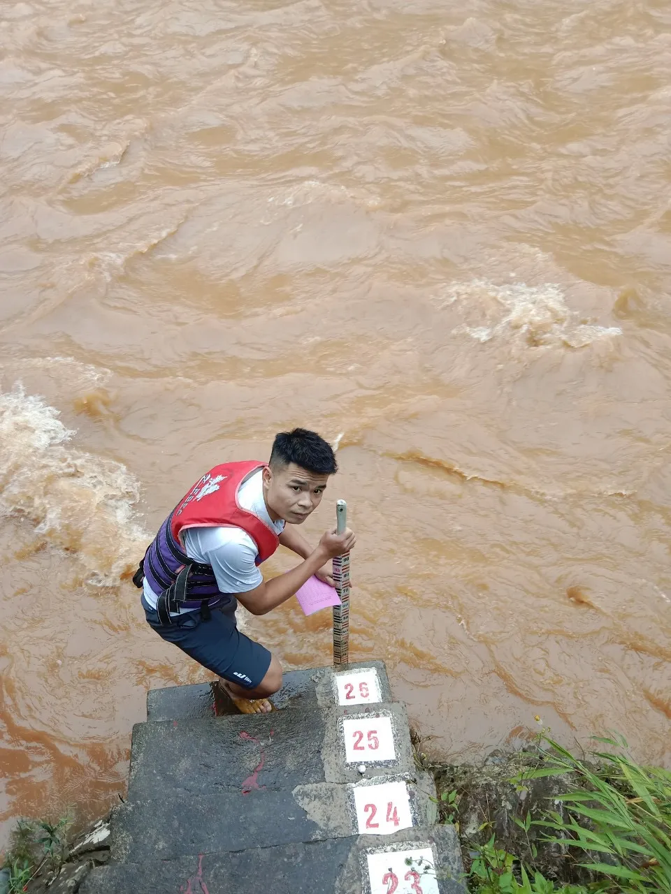 Cán bộ thủy văn đo mức nước lũ trên sông. Ảnh: HOÀI LINH