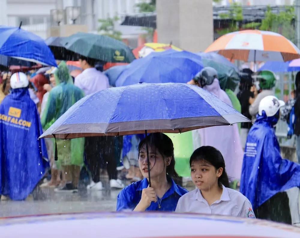 Thí sinh thi vào lớp 10 ở Hà Nội rời điểm thi đúng lúc cơn mưa đổ xuống, chiều 7-6. Ảnh: Theo Đan Phượng Fanpage IMG_9557.jpeg