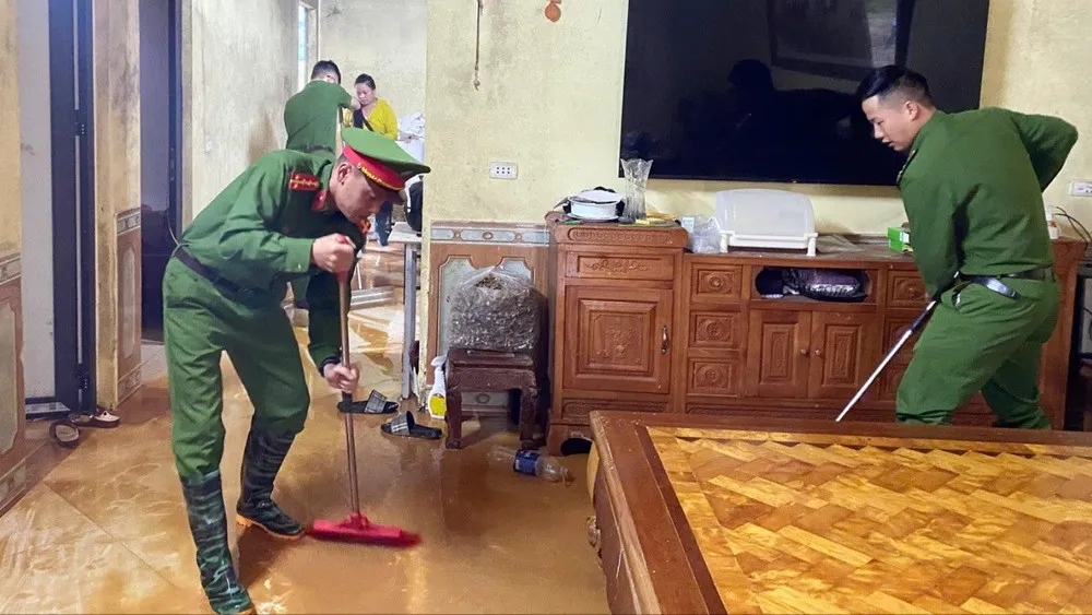 Công an phường Sa Pa hỗ trợ người dân lau dọn nước ngập và bùn đất. Ảnh: TRUYỀN HÌNH SA PA IMG_0374.jpeg