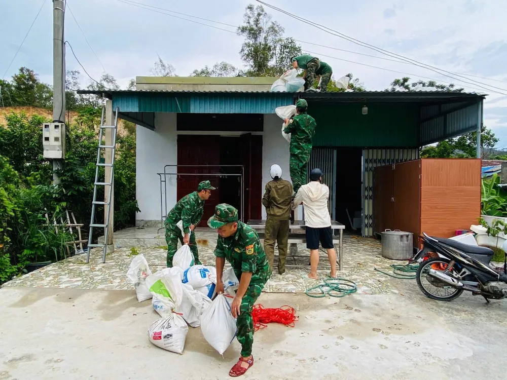 Lực lượng biên phòng trên đảo Cô Tô hỗ trợ người dân đưa bao cát lên gia cố, bảo vệ mái nhà trước cơn bão lớn. Ảnh: BIÊN PHÒNG CÔ TÔ IMG_0586.jpeg