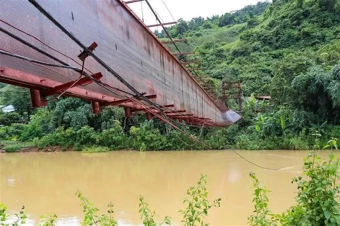 Cây cầu treo bị nghiêng hẳn một bên, hất xe bán tải chở 3 cán bộ xã đi chống bão và 1 người dân đang đi xe máy xuống nước IMG_0657.jpeg