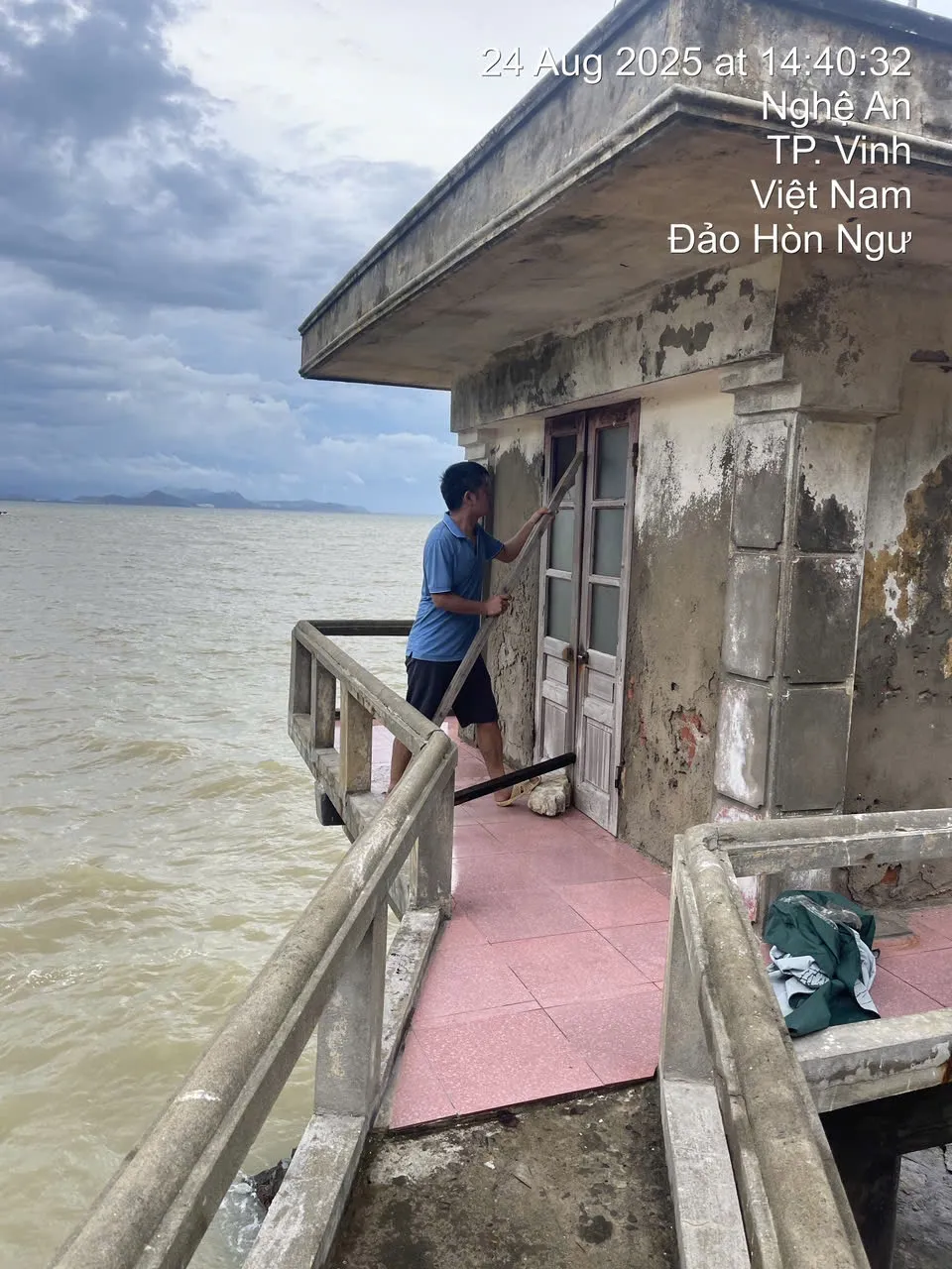Cán bộ khí tượng chằng chống cánh cửa của Trạm Khí tượng Hòn Ngư (đảo Hòn Ngư, tỉnh Nghệ An) vào chiều 24-8. Ảnh: Cục Khí tượng - thủy văn cung cấp IMG_1693.jpeg
