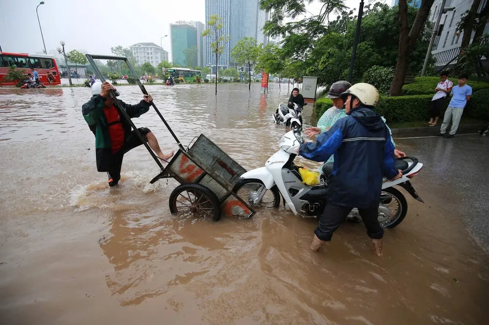 Đại lộ Thăng Long (phía Tây Hà Nội) đã thành sông, người dân sử dụng xe kéo tay chở xe máy qua điểm ngập. Ảnh: CTV IMG_3244.jpeg
