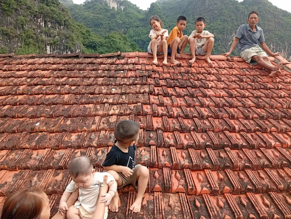 Những đứa trẻ ở xã Hữu Lũng (tỉnh Lạng Sơn) phải sơ tán lên nóc nhà để chờ cứu trợ. Ảnh: NÔNG LOAN IMG_3316.jpeg
