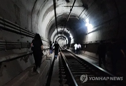 Hành khách toa xe điện ngầm thoát ra qua đường hầm. Ảnh: YONHAP