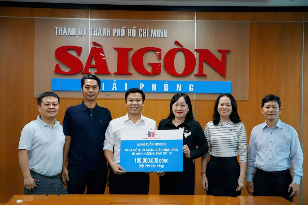 Phó Tổng Biên tập Báo SGGP Bùi Thị Hồng Sương tiếp nhận bảng tượng trưng trị giá 100 triệu đồng từ ông Nguyễn Minh Tuấn, Giám đốc hệ thống Minh Tuấn Mobile. Ảnh: VIỆT NGA z7070581841281_d5b5362c26f8d774d42d94a8d097eb91.jpg