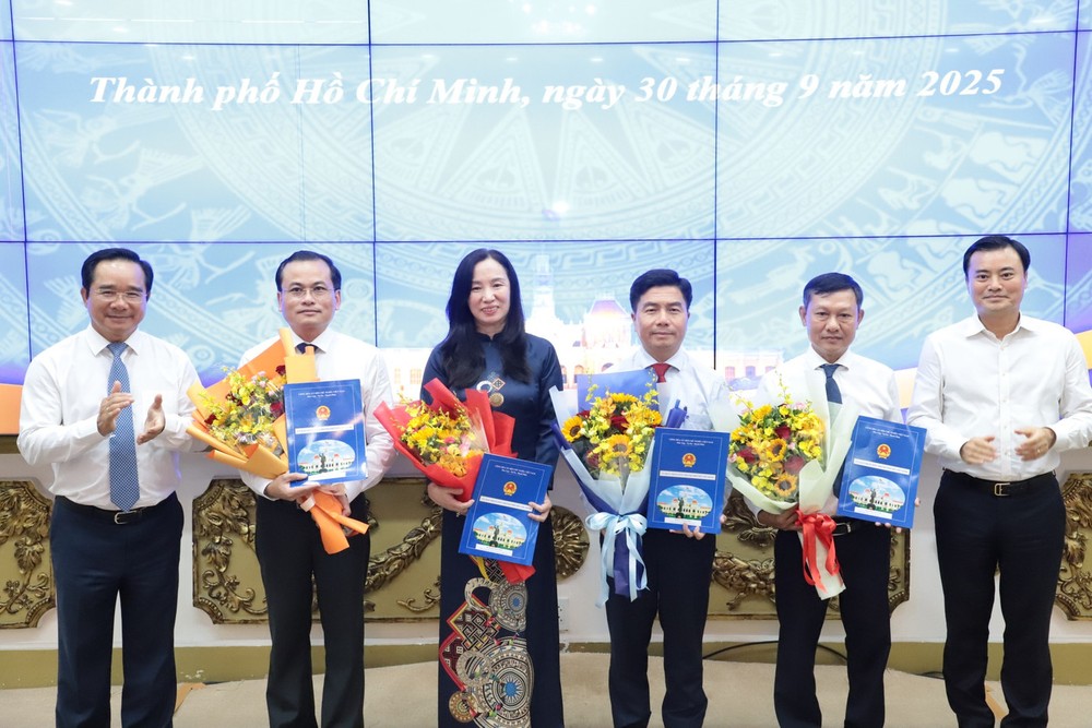 胡志明市人委会主席阮文得与胡志明市人委会副主席裴春强向武黄银（右三）及市规划与建筑厅各副厅长颁授决定并献花祝贺。