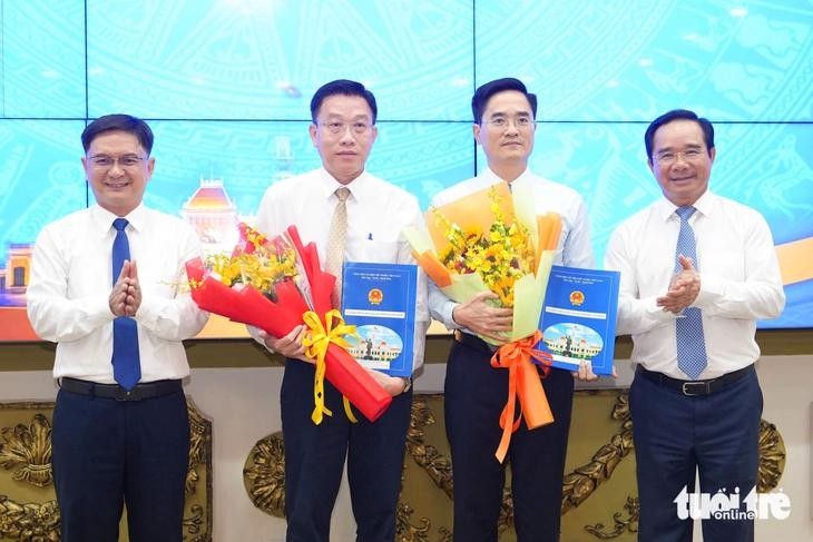 胡志明市人委会主席阮文得（右）与市人委会副主席阮孟强（左）向市建设厅长陈光林（右二）和市交通工程投建项目管委会主任阮英明颁授委任决定。