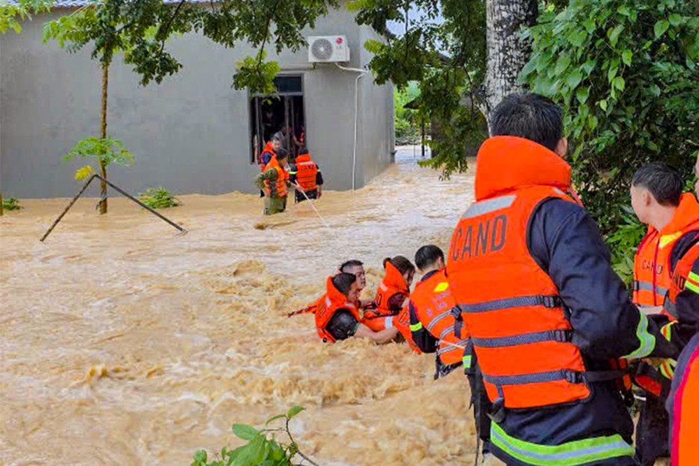 警察力量使用专用绳索将被洪水围困的民众转移到安全地带 。
