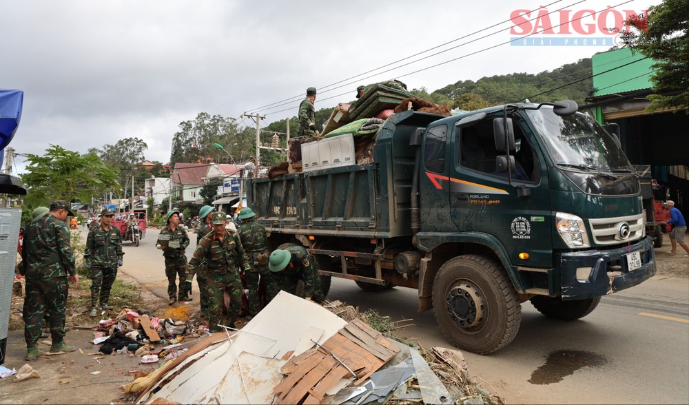 第七军区干部、战士帮助居民清理房屋和沿着林同省德兰乡27号国道的道路。 