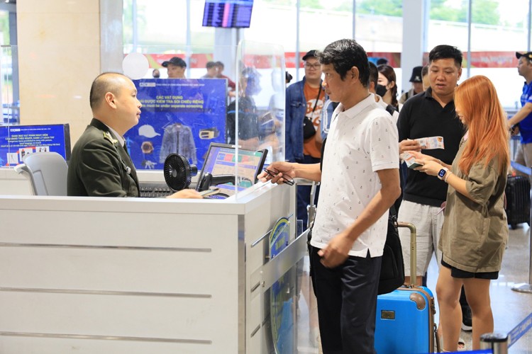  乘客经过安检门。 