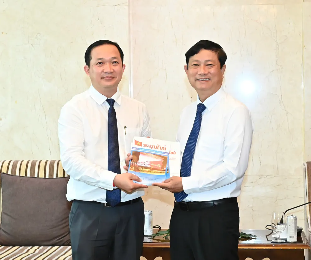 Đồng chí Vanlaty Khamvanvongsa, Tổng Biên tập Tạp chí Alunmay gửi tặng tạp chí đến Phó Bí thư Thành ủy TPHCM, Chủ tịch HĐND TPHCM Võ Văn Minh. Ảnh: VIỆT DŨNG 4.jpg