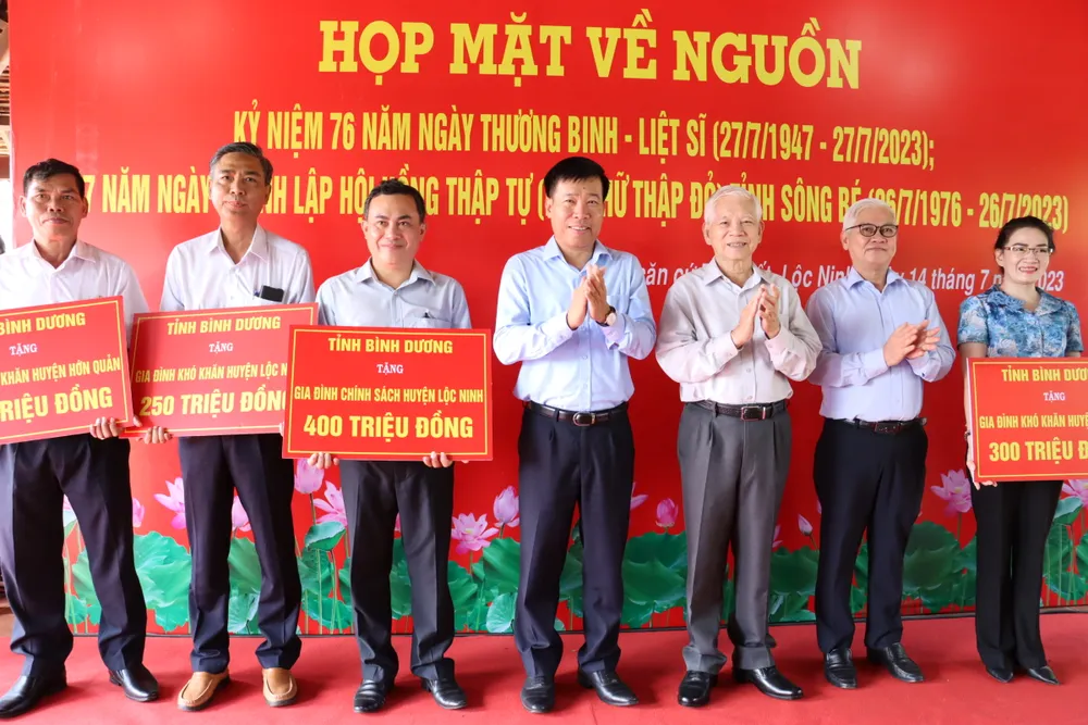 Nguyên Ủy viên Bộ Chính trị, nguyên Chủ tịch nước Nguyễn Minh Triết cùng lãnh đạo Bình Dương và Bình Phước trao bảng tượng trưng hỗ trợ kinh phí tặng quà gia đình chính sách, gia đình khó khăn trên địa bàn tỉnh Bình Phước