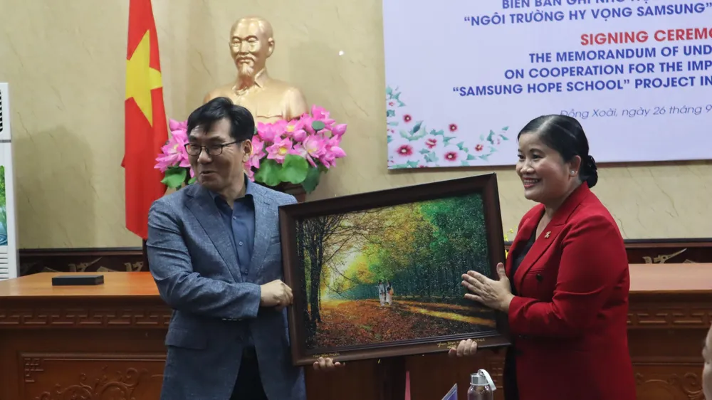 Bà Trần Tuệ Hiền, Chủ tịch UBND tỉnh Bình Phước trao tặng quà cho ông Choi Joo Ho, Tổng Giám đốc Tổ hợp Samsung Việt Nam tại lễ ký kết Bà Trần Tuệ Hiền, Chủ tịch UBND tỉnh Bình Phước trao tặng quà cho ông Choi Joo Ho, Tổng Giám đốc Tổ hợp Samsung Việt Nam tại lễ ký kết