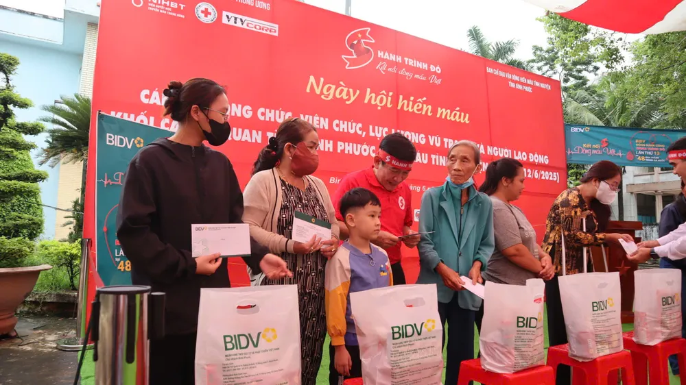 Tặng quà cho các hộ gia đình hiến máu tình nguyện có hoàn cảnh khó khăn, hộ gia đình nạn nhân chất độc da cam và người mù có hoàn cảnh khó khăn tại buổi lễ (2).jpg