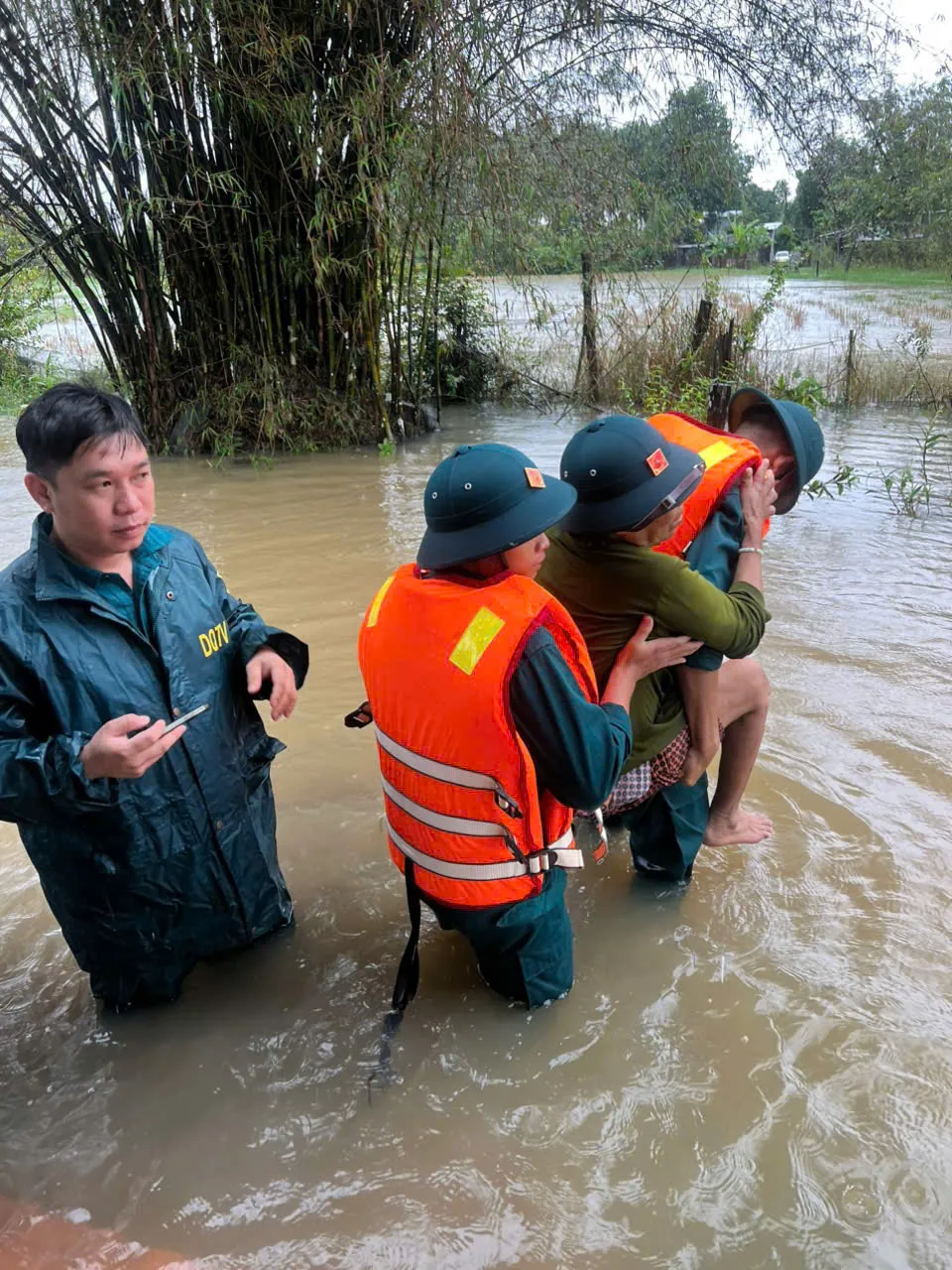 Cán bộ, chiến sĩ Ban Chỉ huy Quân sự xã Thiện Hưng cõng bà Nguyễn Thị Bạch Tuyết, sinh năm 1950, bị tai biến đến nơi an toàn - 1.jpg