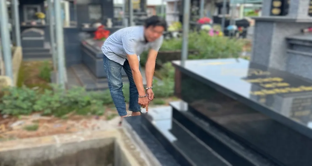 Đối tượng T.M.N. tại ngôi mộ ông Phạm Hữu T. sau khi đã được sửa chữa lại 3.jpg