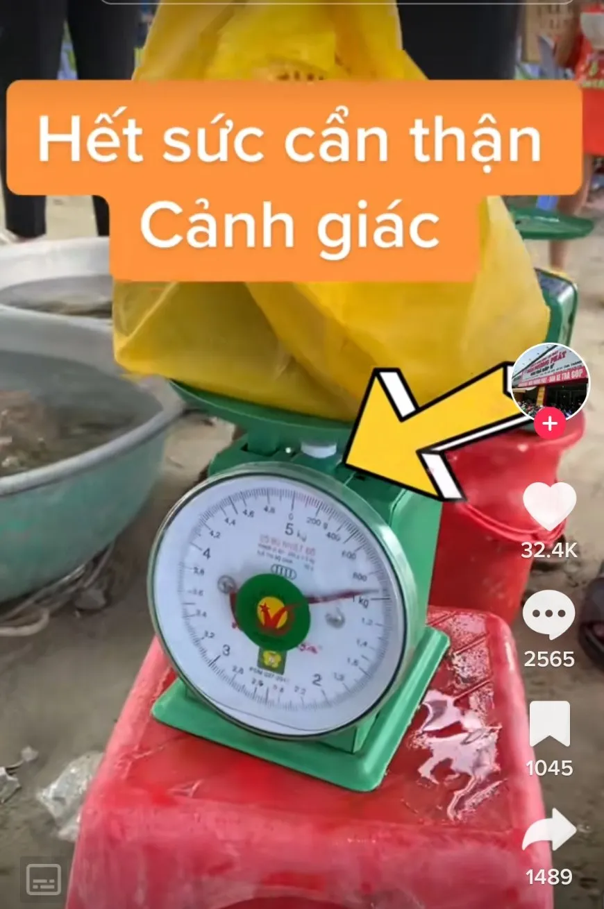 Một chiếc cân của bà M. khi cân 3 lon bia có trọng lượng gần 1kg. Ảnh cắt từ clip Một chiếc cân của bà M. khi cân 3 lon bia có trọng lượng gần 1kg. Ảnh cắt từ clip