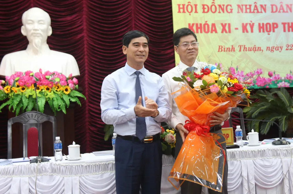 Bí thư Tỉnh ủy Bình Thuận Dương Văn An tặng hoa chúc mừng tân Phó Chủ tịch UBND tỉnh Bình Thuận Nguyễn Hồng Hải (bên phải)