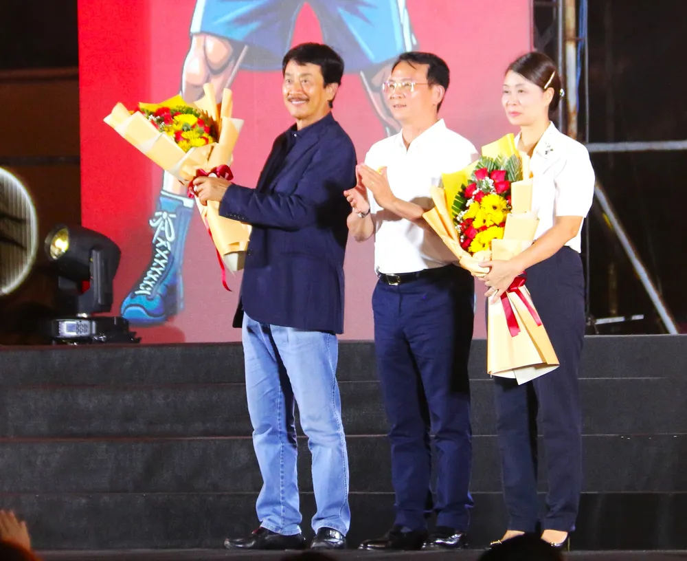 Ông Hồ Văn Mười, Chủ tịch UBND tỉnh Lâm Đồng (giữa) trao hoa cho ông Bùi Thành Nhơn, Chủ tịch NovaGroup và các nhà tài trợ