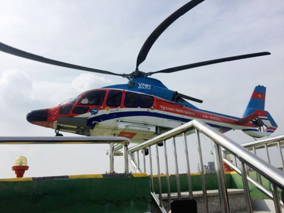 A helicopter lands on the top of Times Square building, Nguyen Hue street, downtown HCMC