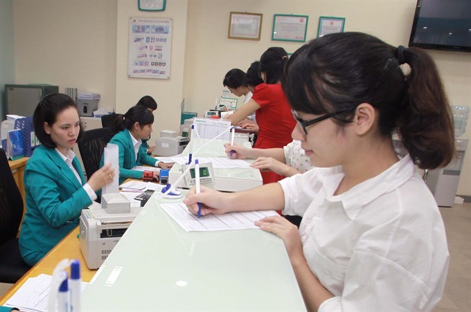 Customers make transactions at ABBank branch office in Thai Binh Province. (Photo: VNA)