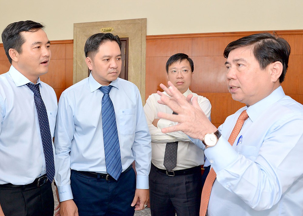 Chairman of the HCMC People’s Committee Nguyen Thanh Phong (R) talks to delegates at the 10th conference of the 10th city Party Committee on June 28 (Photo: SGGP)