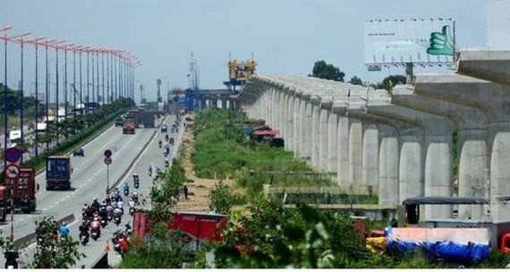 The pillars on the right of the photo is the under construction above ground stretch of the first metro line Ben Thanh-Suoi Tien in HCMC (Photo: SGGP)