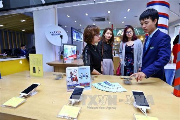 Customers try Mobifone’s service. Mobifone’s acquisition of 95% of AVG shares will be investigated. (Photo: VNA)