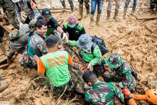 Rescue workers carry a body bag containing remains of victims following a landslide at Cisolok district in Sukabumi (Source: Reuters/ANTARA)