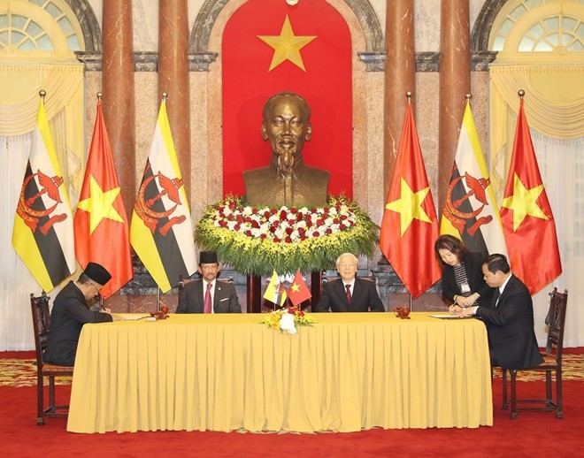 Party General Secretary and President Nguyen Phu Trong (right) and Brunei's Sultan Haji Hassanal Bolkiah witnessed the signing of a memorandum of understanding (MoU) on the use of a hotline to deal with illegal, unreported, and unregulated (IUU) fishing b