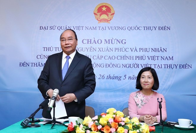 Prime Minister Nguyen Xuan Phuc (standing) speaks at the meeting with the Vietnamese Embassy staff and expatriates in Sweden. (Photo: VNA)