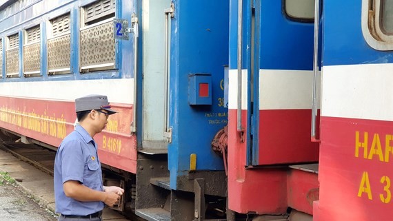 A station staff waiting outside the train to Dong Dang at Gia Lam station. Photo: SGGP