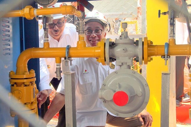 Upstream Oil and Gas Regulatory Special Task Force (SKKMigas) head Dwi Soetjipto turns a handle on a gas pipe at a gas network installation in Gunung Sari Ulu subdistrict, Balikpapan, East Kalimantan, while Balikpapan Mayor Rizal Effendi helps him. (Sourc