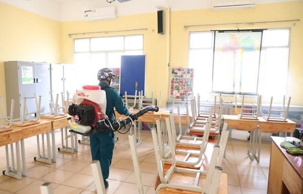 A worker sprays disinfectant at a classroom of the Viet Duc High School in Hanoi's Hoan Kiem district on February 2 (Photo: VNA)